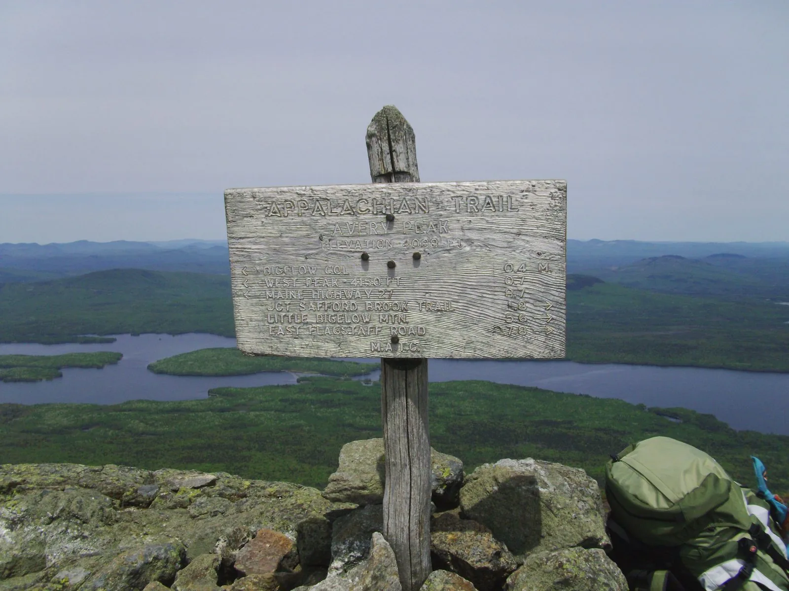 Appalachian Trail sign on Avery Peak summit with Flagstaff Lake visible below, Bigelow Range Maine
