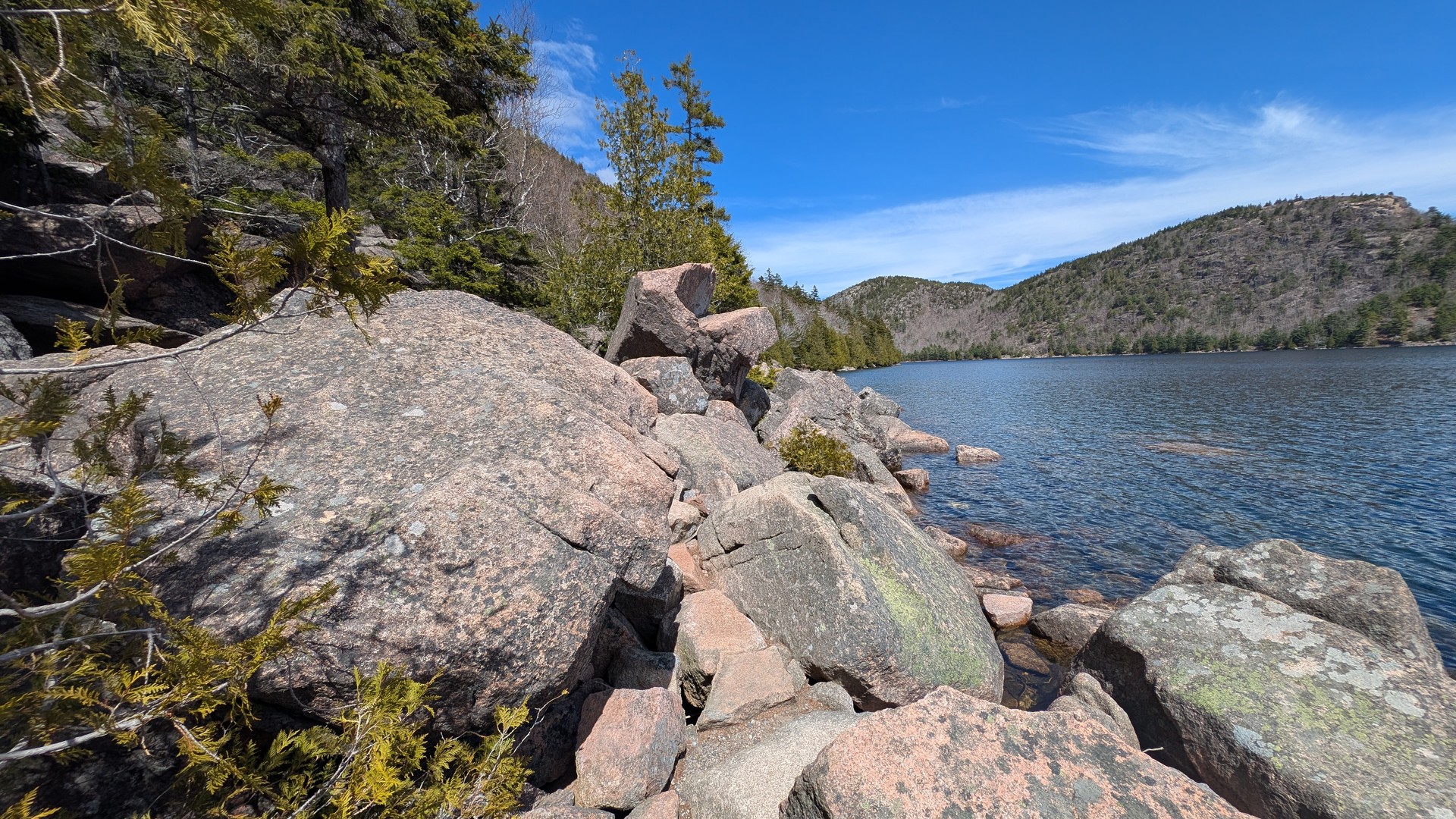 Rock hopping along the north shore of Jordan Pond — the path follows the waterline between boulders on the return leg