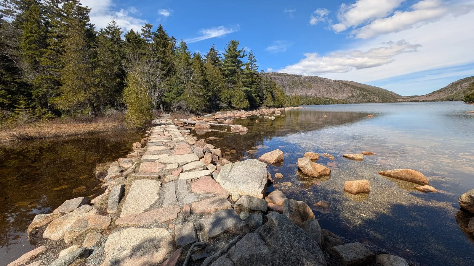 Stone outlet bridge at the southern end of Jordan Pond — the start of the stream draining to the carriage roads below