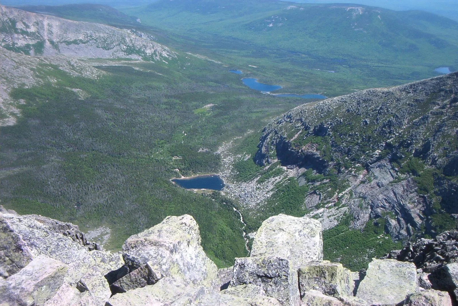 View from the Knife Edge rim looking down into the South Basin — Chimney Pond and ranger station below, Togue Pond visible in the distant lowlands