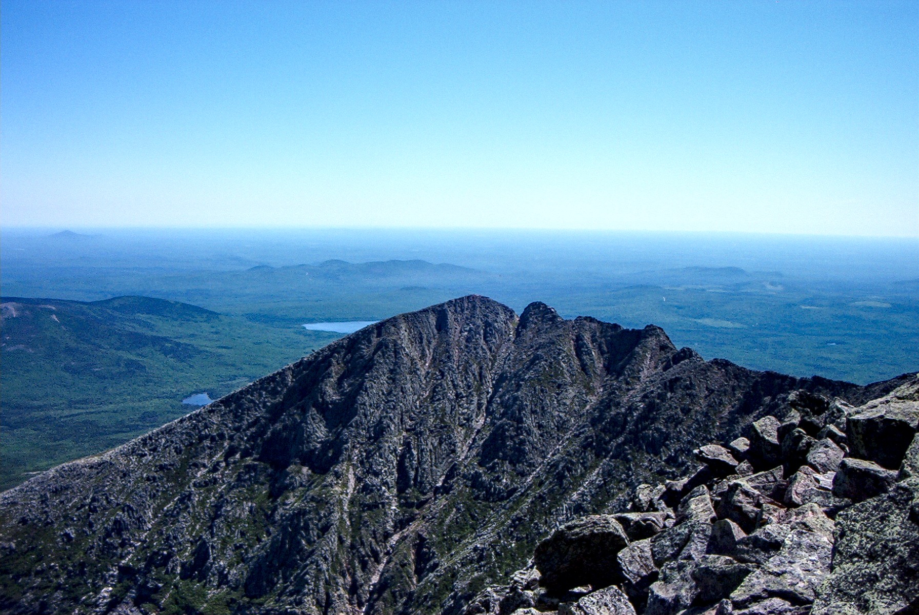 Hikers traversing the Knife Edge ridge on Mount Katahdin, Maine's highest peak, with thousand-foot drops on both sides