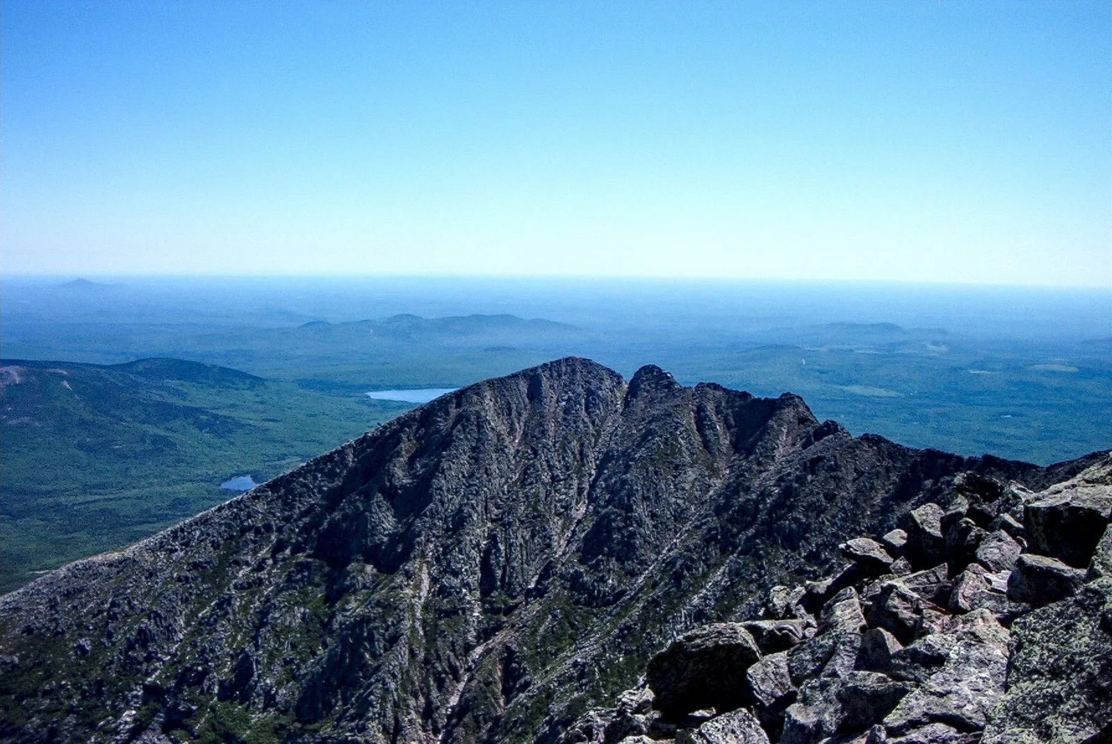Hikers traversing the Knife Edge ridge on Mount Katahdin, Maine's highest peak, with thousand-foot drops on both sides